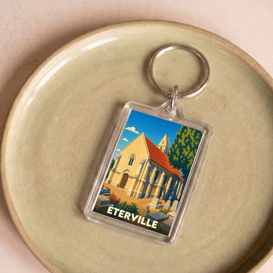 Porte-clés souvenir de la ville de Éterville avec une illustration stylisée de son église.