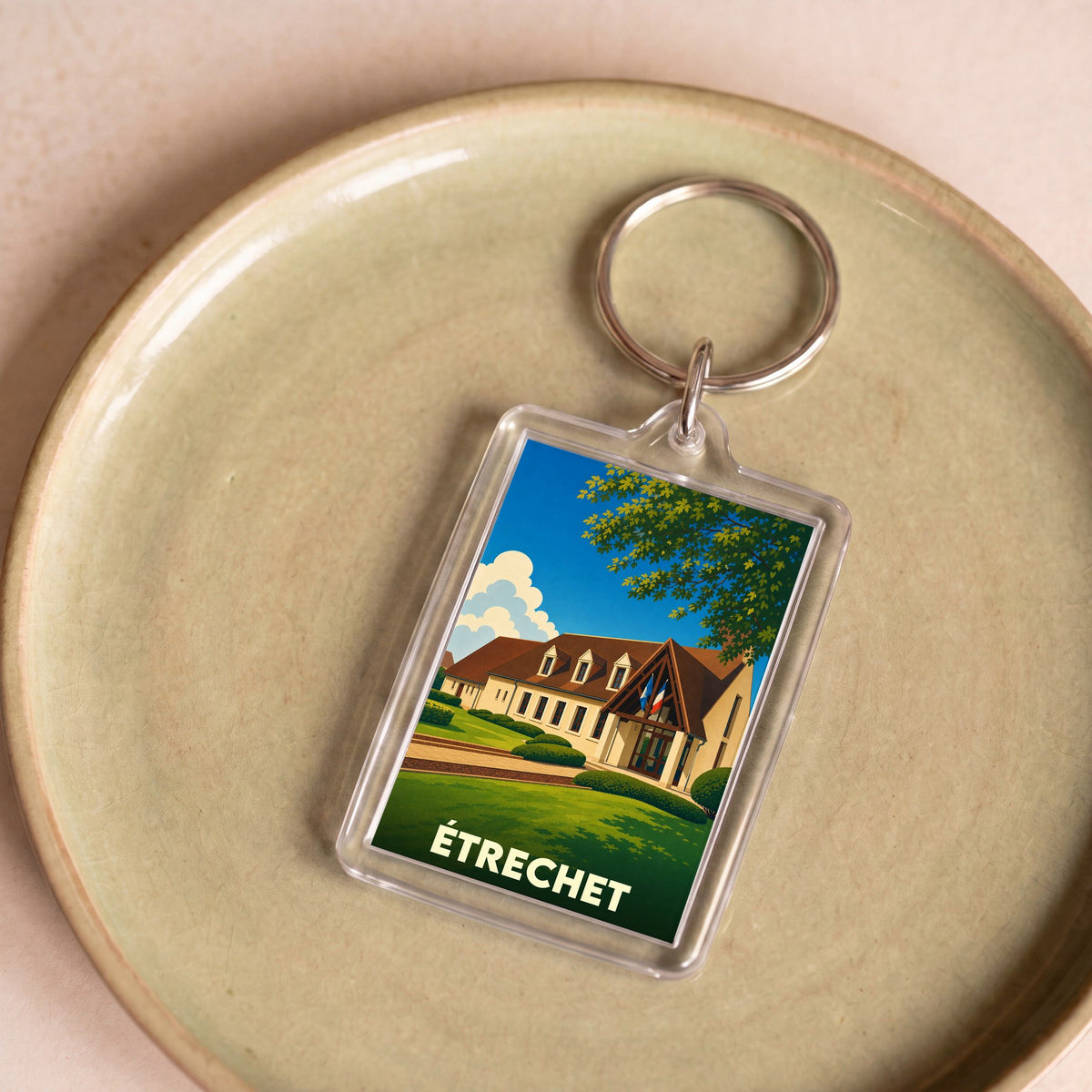 Porte-clés souvenir de la ville d'Étrechet avec une illustration stylisée de sa mairie.