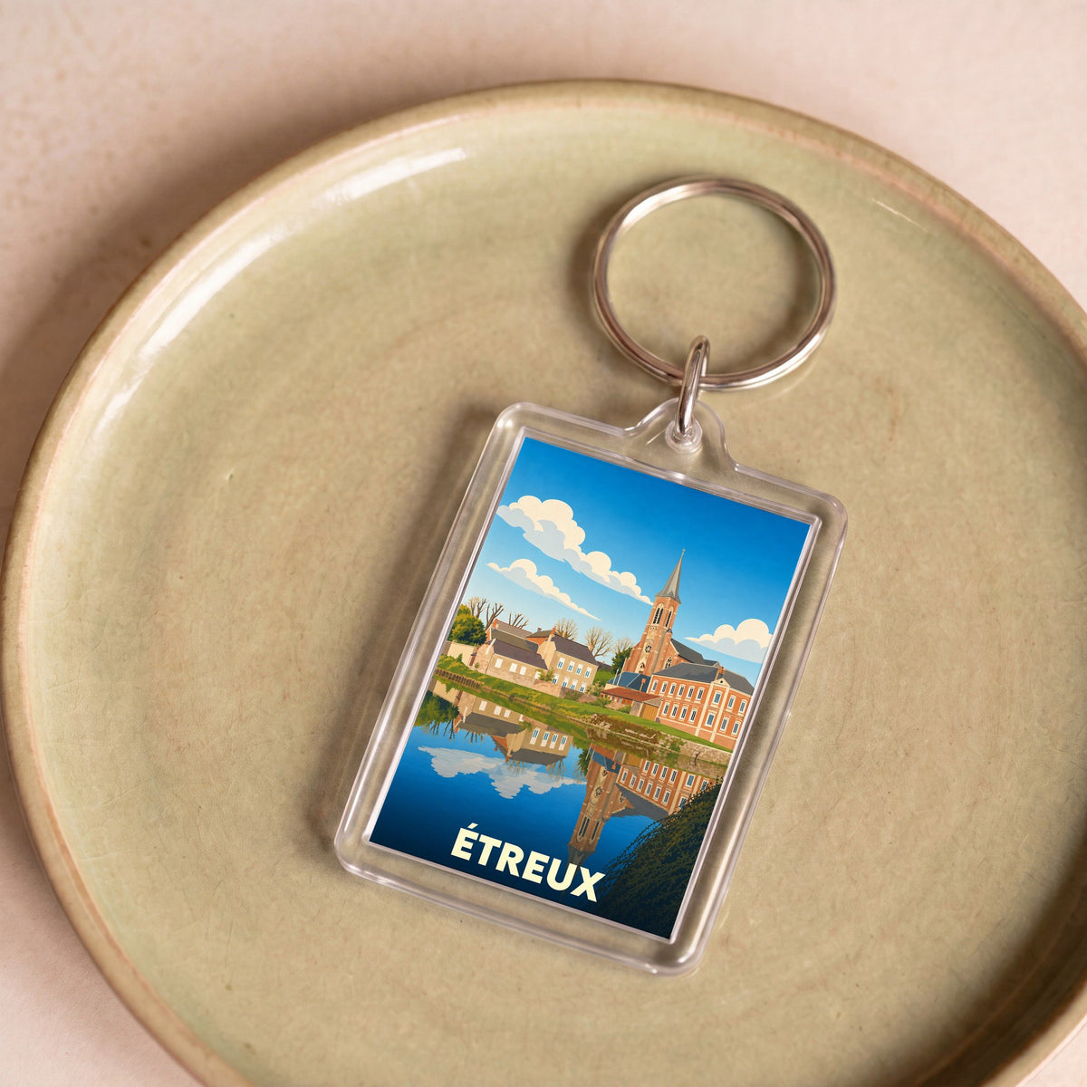 Porte-clés souvenir de la ville d'Étreux avec une illustration stylisée.