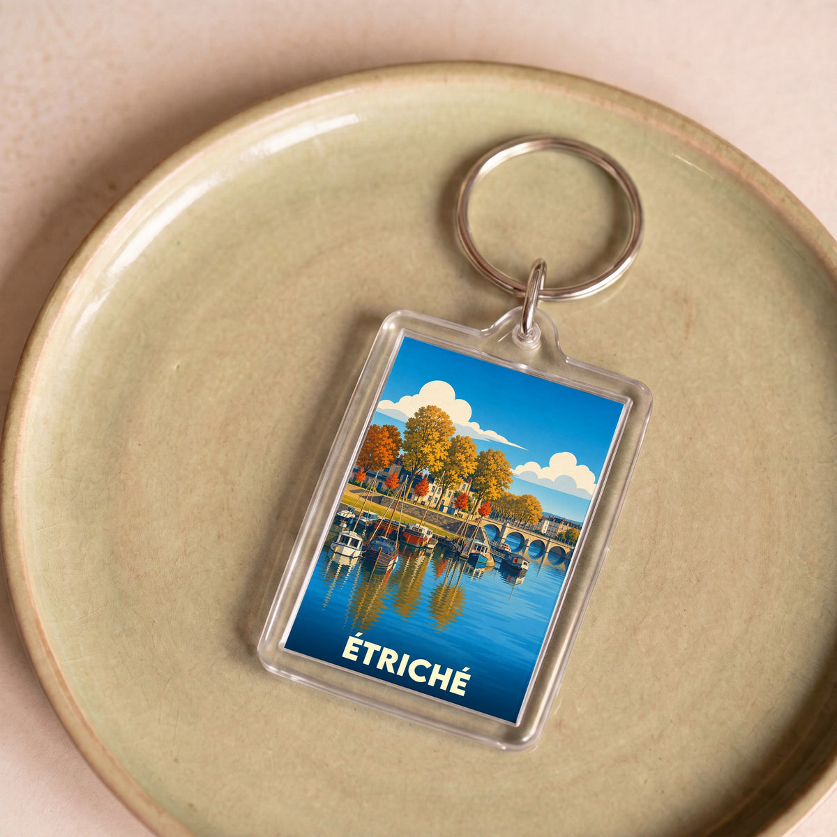 Porte-clés souvenir de la ville de Étriché avec une illustration stylisée d'un port fluvial.
