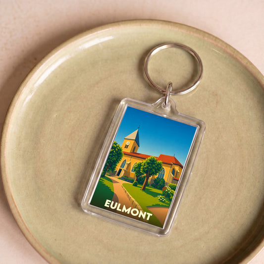 Porte-clés souvenir de la ville d'Eulmont avec une illustration stylisée de son église et d'un jardin.