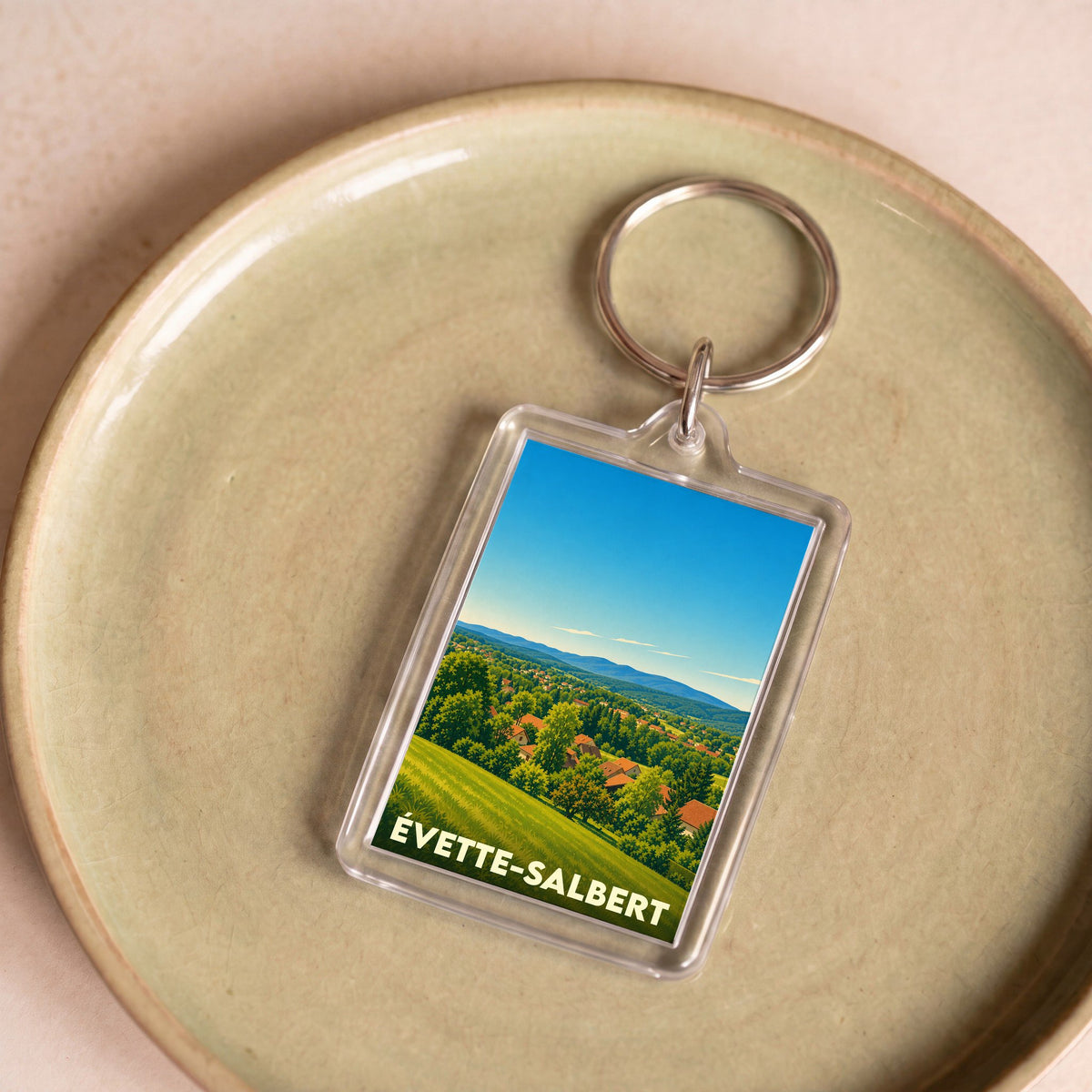 Porte-clés souvenir de la ville d'Évette-Salbert avec une illustration stylisée de son paysage vallonné.