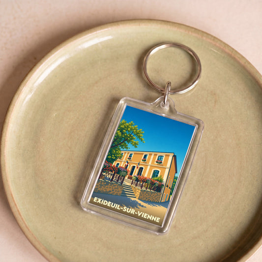 Porte-clés souvenir de la ville d'Exideuil-sur-Vienne avec une illustration stylisée.