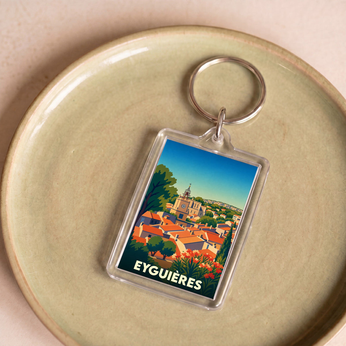 Porte-clés souvenir de la ville d'Eyguières avec une illustration stylisée de ses toits provençaux.