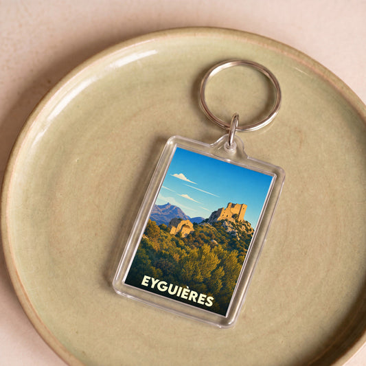 Porte-clés souvenir de la ville d'Eyguières avec une illustration stylisée d'un château perché.
