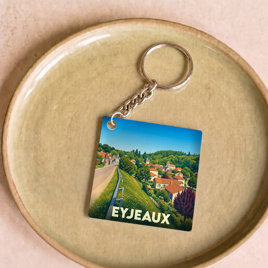 Porte-clés souvenir de la ville d'Eyjeaux avec une illustration stylisée du paysage local.