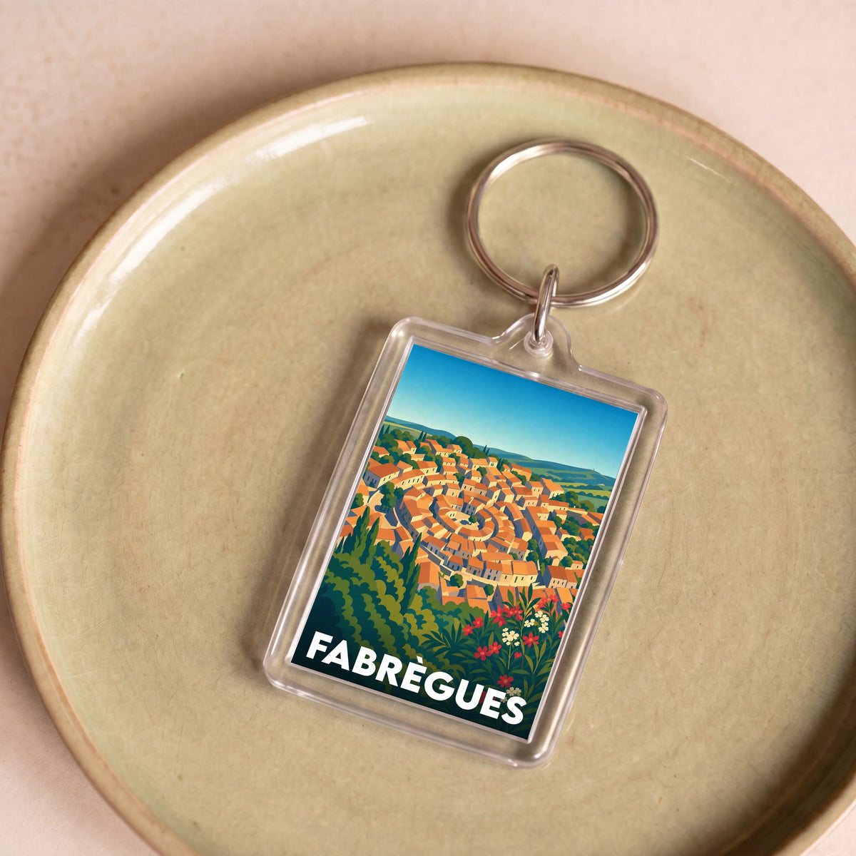 Porte-clés souvenir de la ville de Fabrègues avec une illustration stylisée.