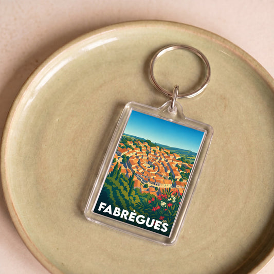 Porte-clés souvenir de la ville de Fabrègues avec une illustration stylisée.