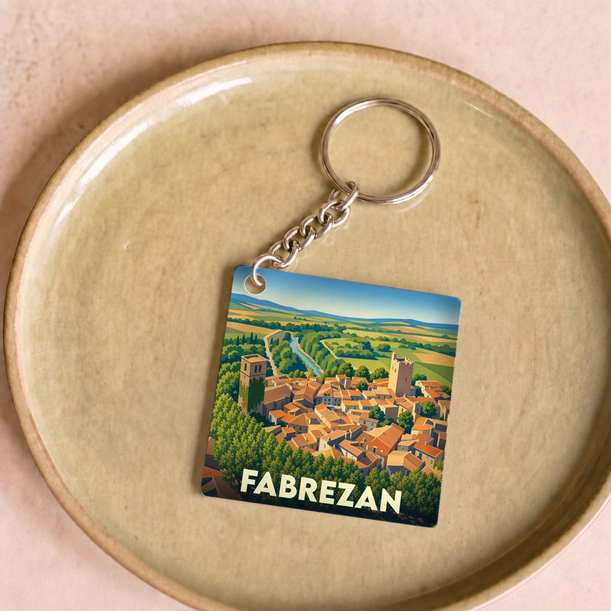 Porte-clés souvenir de la ville de Fabrezan avec une illustration stylisée.