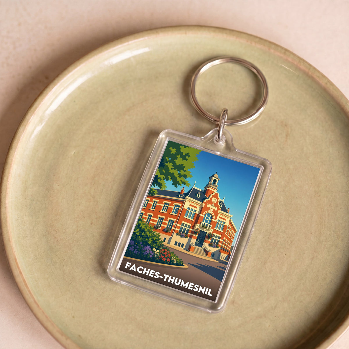Porte-clés souvenir de la ville de Faches-Thumesnil avec une illustration stylisée.