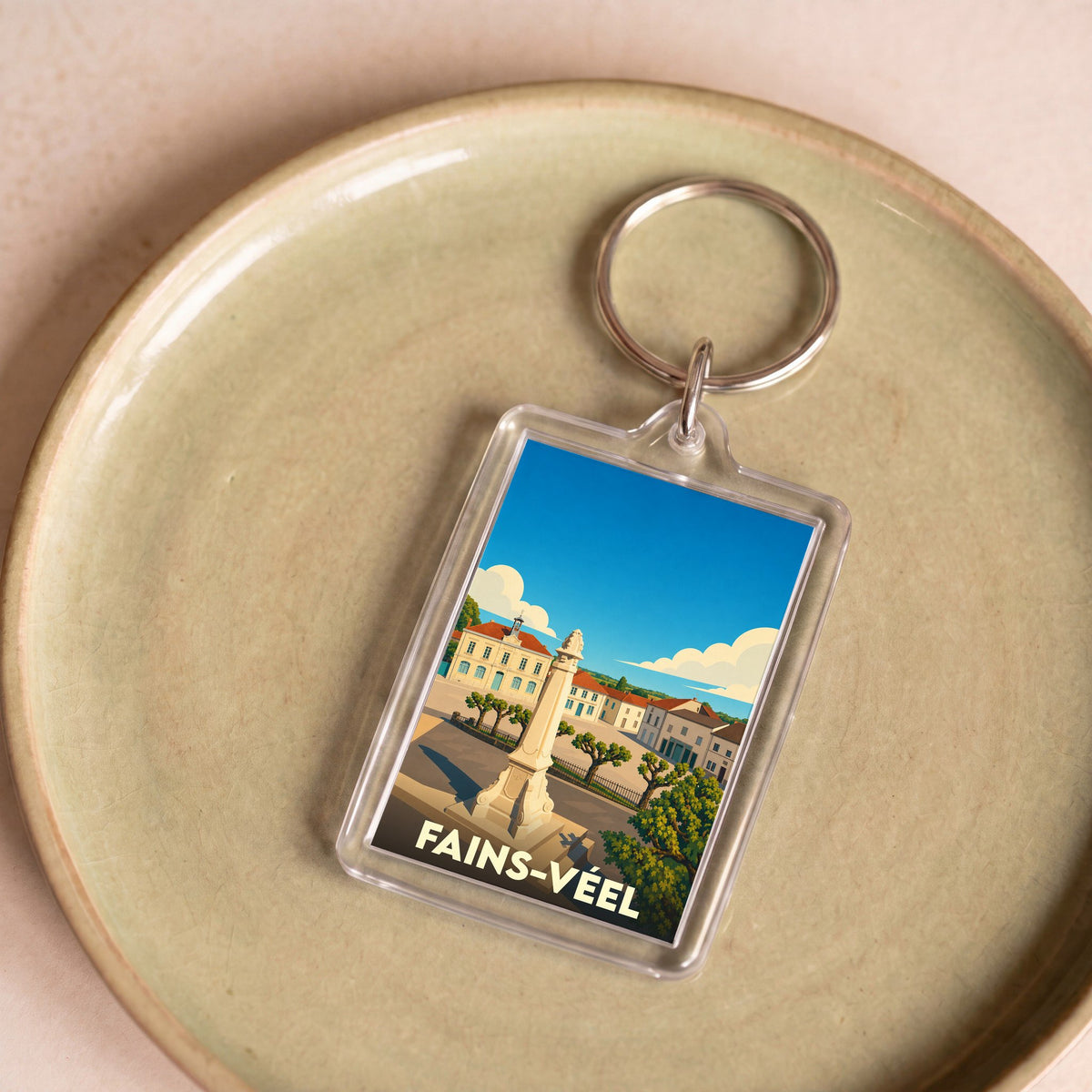 Porte-clés souvenir de la ville de Fains-Véel avec une illustration stylisée.