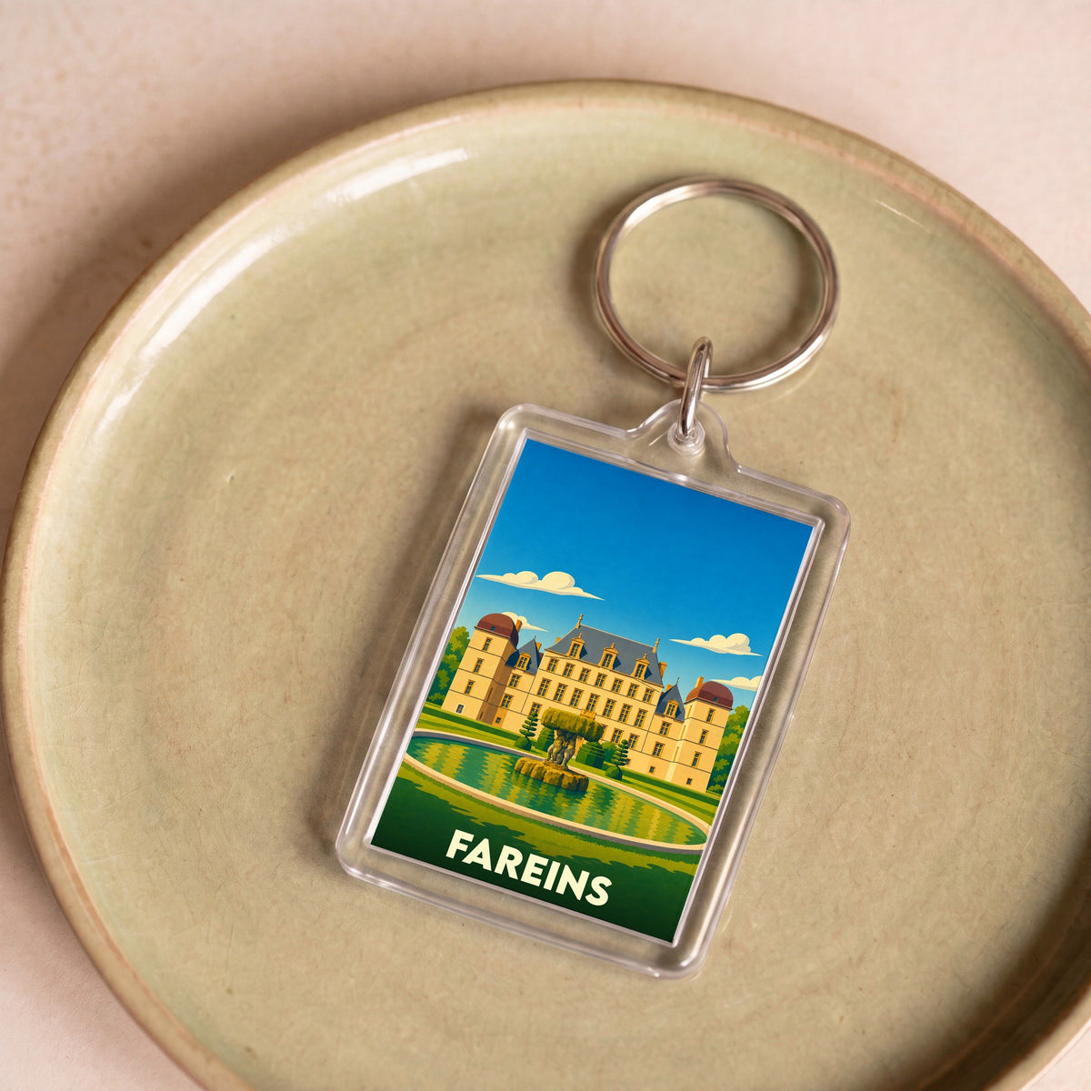 Porte-clés souvenir de la ville de Fareins avec une illustration stylisée de son château.