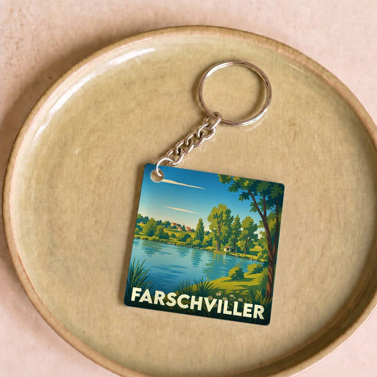 Porte-clés souvenir de la ville de Farschviller avec une illustration stylisée d'un paysage naturel.