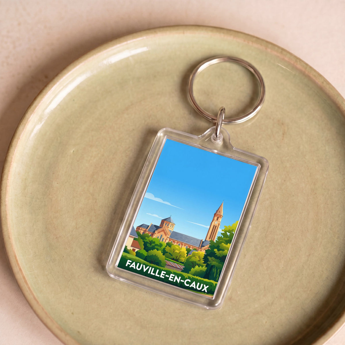 Porte-clés souvenir de la ville de Fauville-en-Caux avec une illustration stylisée de son église.