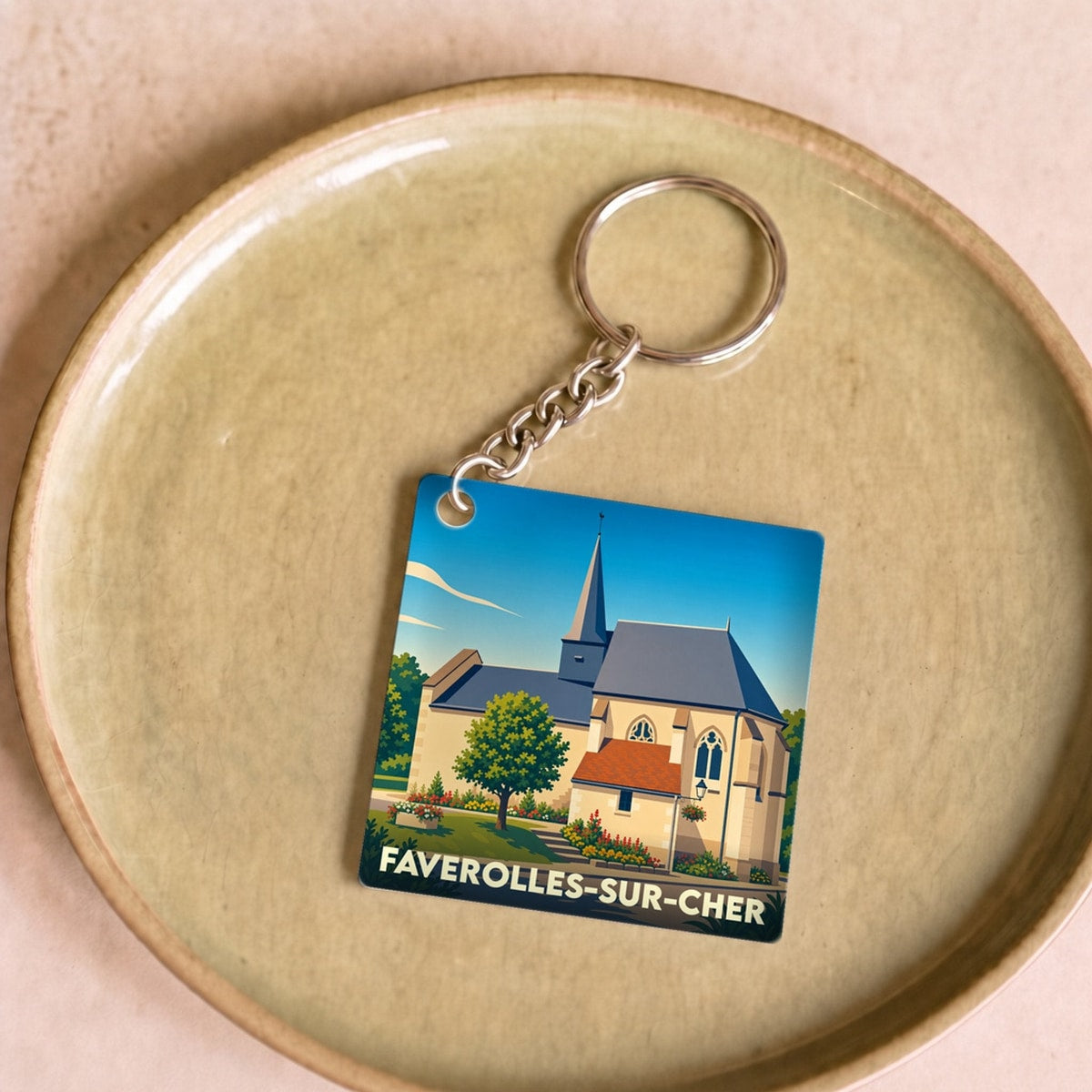 Porte-clés souvenir de la ville de Faverolles-sur-Cher avec une illustration stylisée de son église.