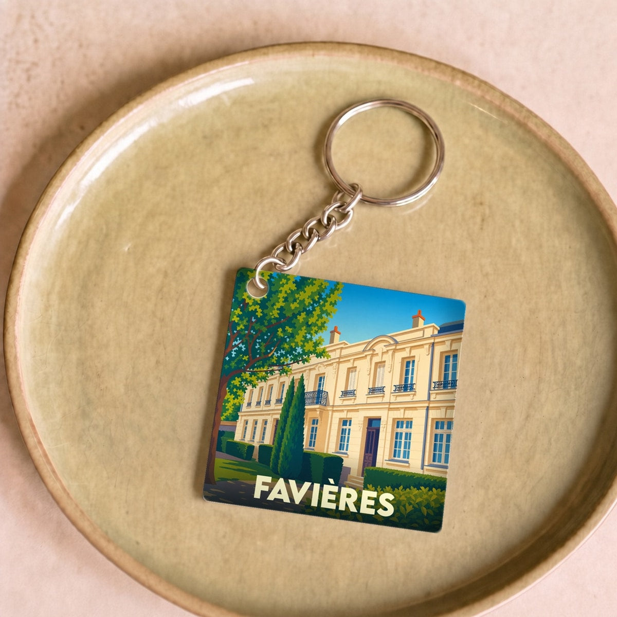 Porte-clés souvenir de la ville de Favières avec une illustration stylisée d'un bâtiment historique.