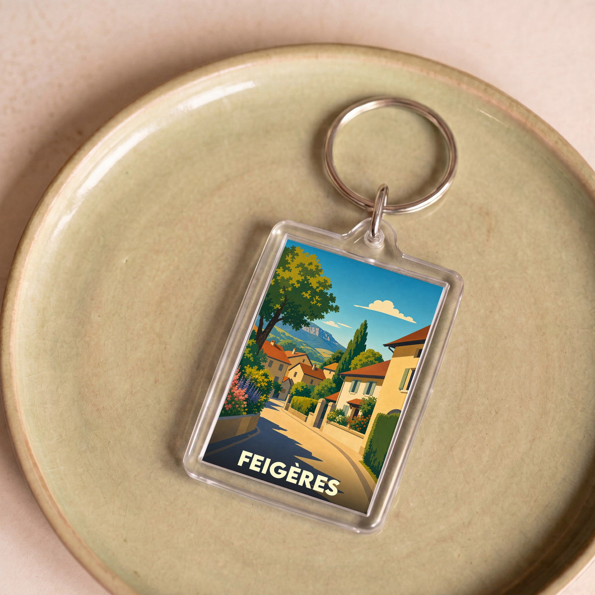 Porte-clés souvenir de la ville de Feigères avec une illustration stylisée.