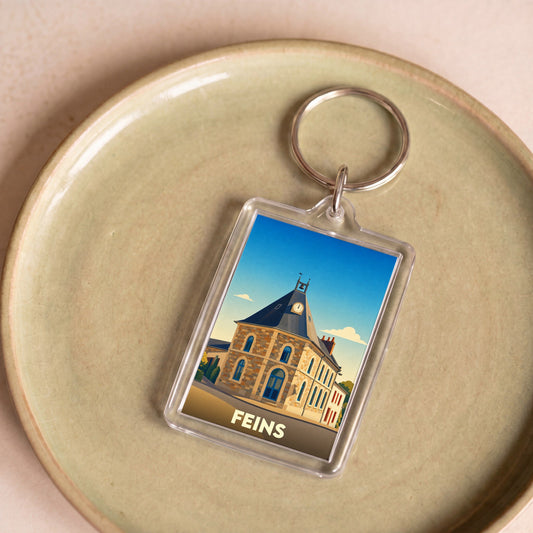 Porte-clés souvenir de la ville de Feins avec une illustration stylisée de son église.