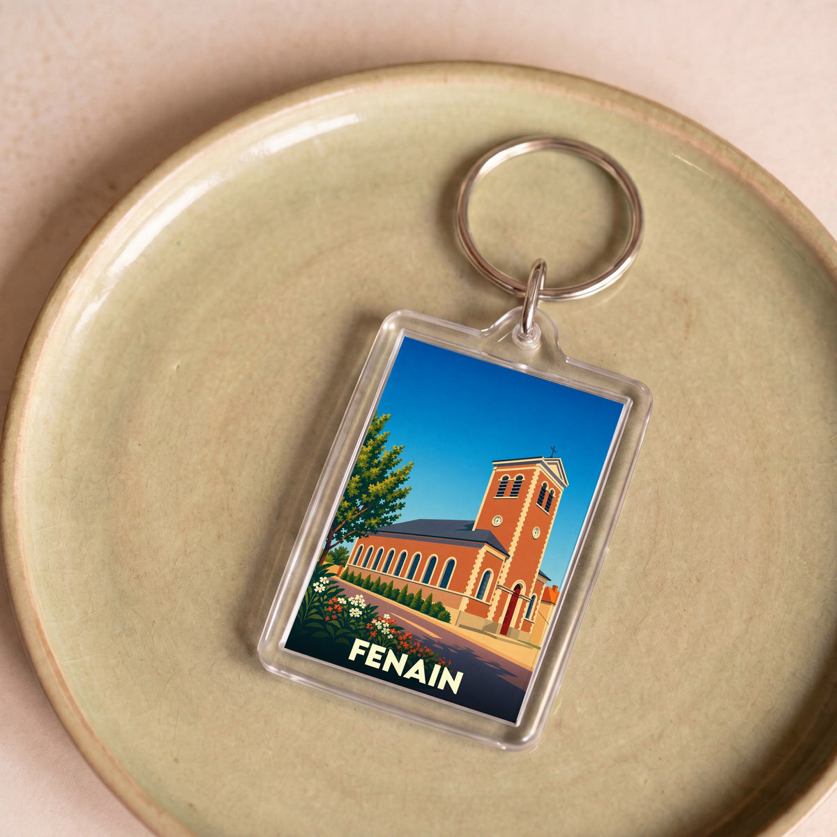 Porte-clés souvenir de la ville de Fenain avec une illustration stylisée de son église.