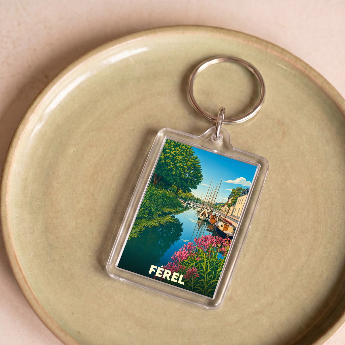 Porte-clés souvenir de la ville de Férel avec une illustration stylisée d'un port fleuri.
