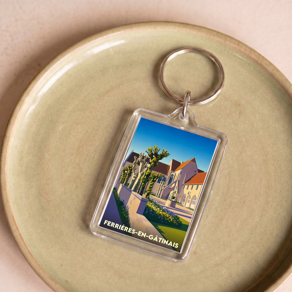 Porte-clés souvenir de la ville de Ferrières-en-Gâtinais avec une illustration stylisée de son patrimoine.