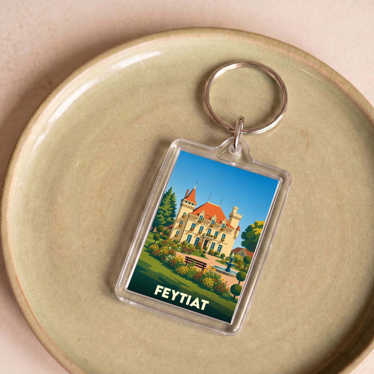Porte-clés souvenir de la ville de Feytiat avec une illustration stylisée d'un château fleuri.