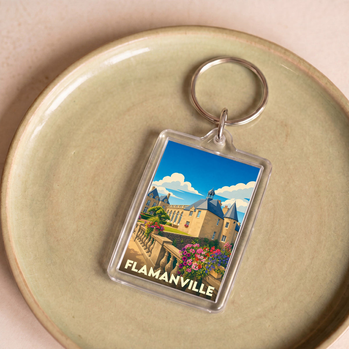Porte-clés souvenir de la ville de Flamanville avec une illustration stylisée de son château.