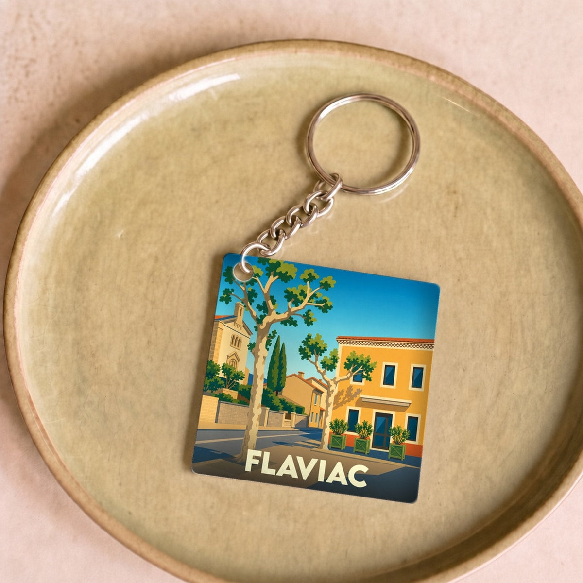 Porte-clés souvenir de la ville de Flaviac avec une illustration stylisée.