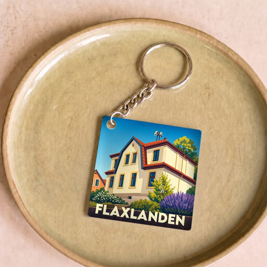Porte-clés souvenir de la ville de Flaxlanden avec une illustration stylisée d'une maison traditionnelle.