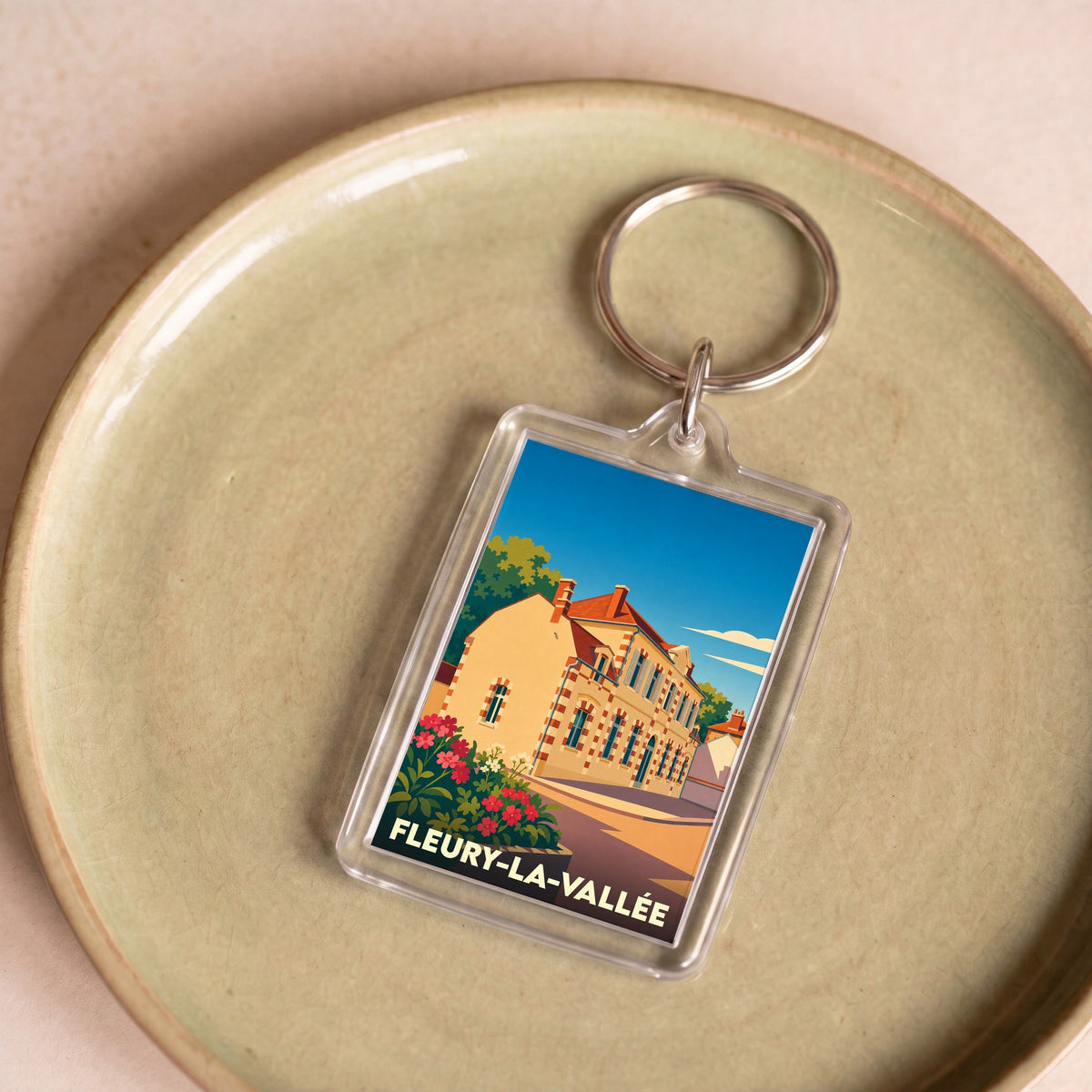 Porte-clés souvenir de la ville de Fleury-la-Vallée avec une illustration stylisée.