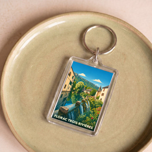 Porte-clés souvenir de Florac Trois Rivières avec une illustration stylisée d'un paysage urbain et de sa cascade.