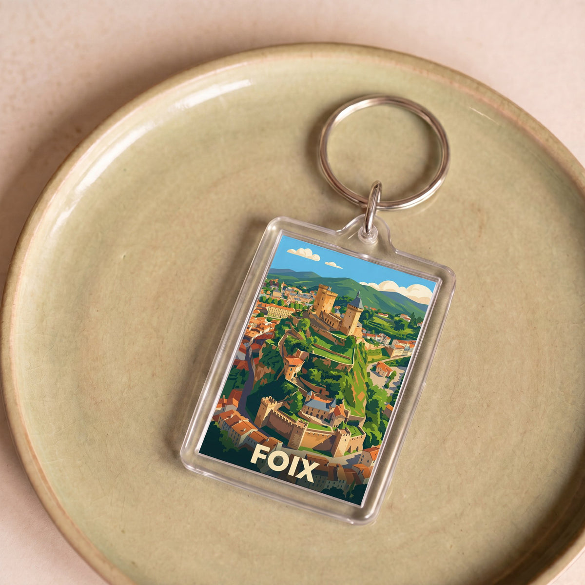 Porte-clés souvenir de la ville de Foix avec une illustration stylisée.
