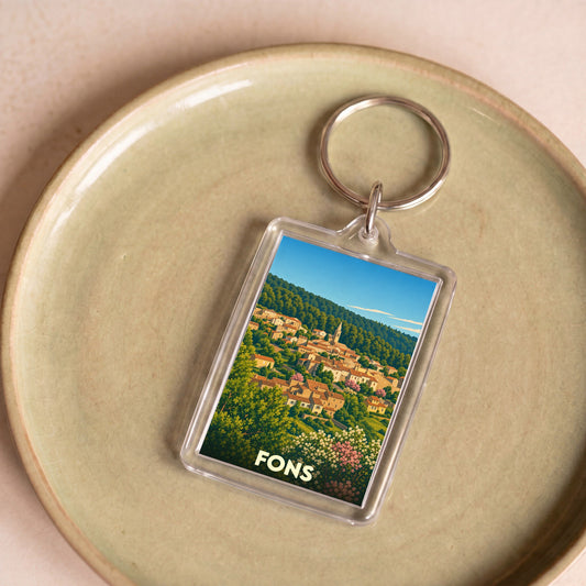 Porte-clés souvenir de la ville de Fons avec une illustration stylisée d'un village perché.