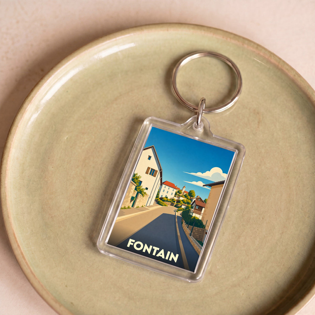 Porte-clés souvenir de la ville de Fontain avec une illustration stylisée.