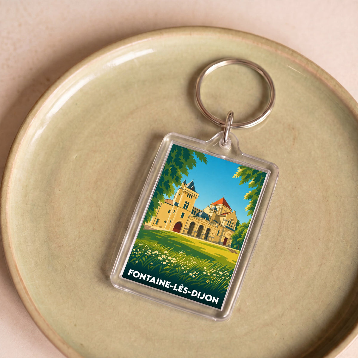 Porte-clés souvenir de la ville de Fontaine-lès-Dijon avec une illustration stylisée du patrimoine local.