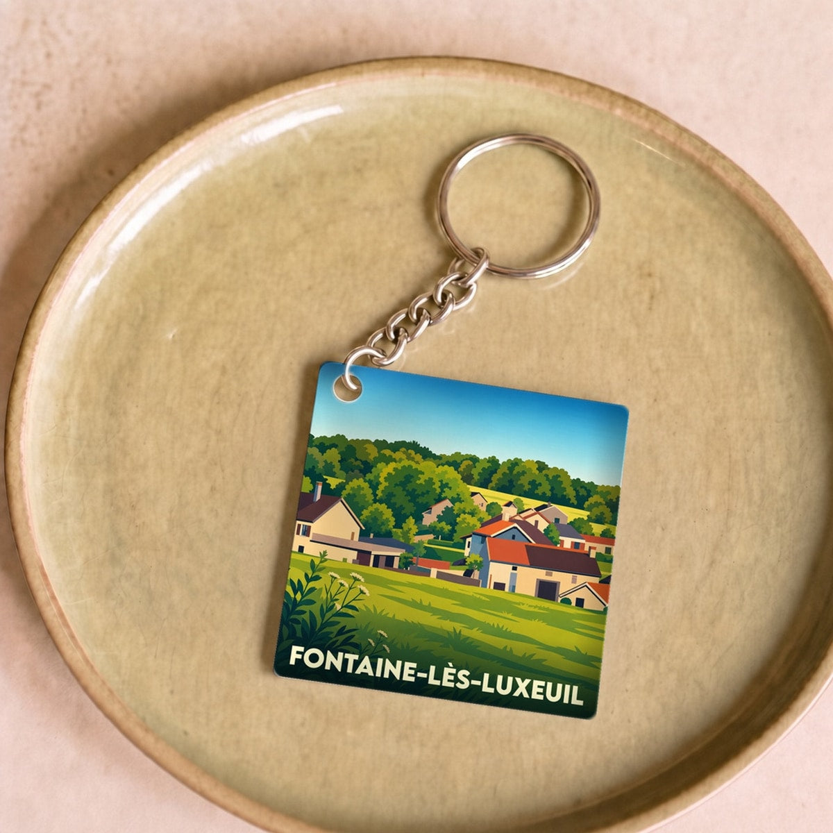 Porte-clés souvenir de la ville de Fontaine-lès-Luxeuil avec une illustration stylisée.
