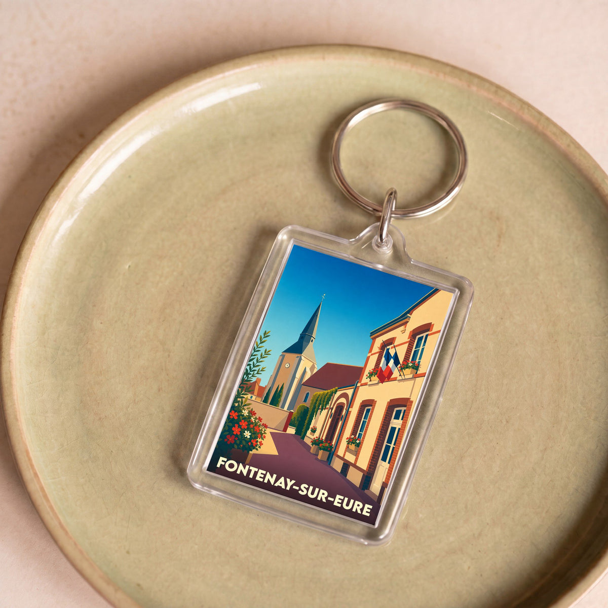 Porte-clés souvenir de la ville de Fontenay-sur-Eure avec une illustration stylisée.