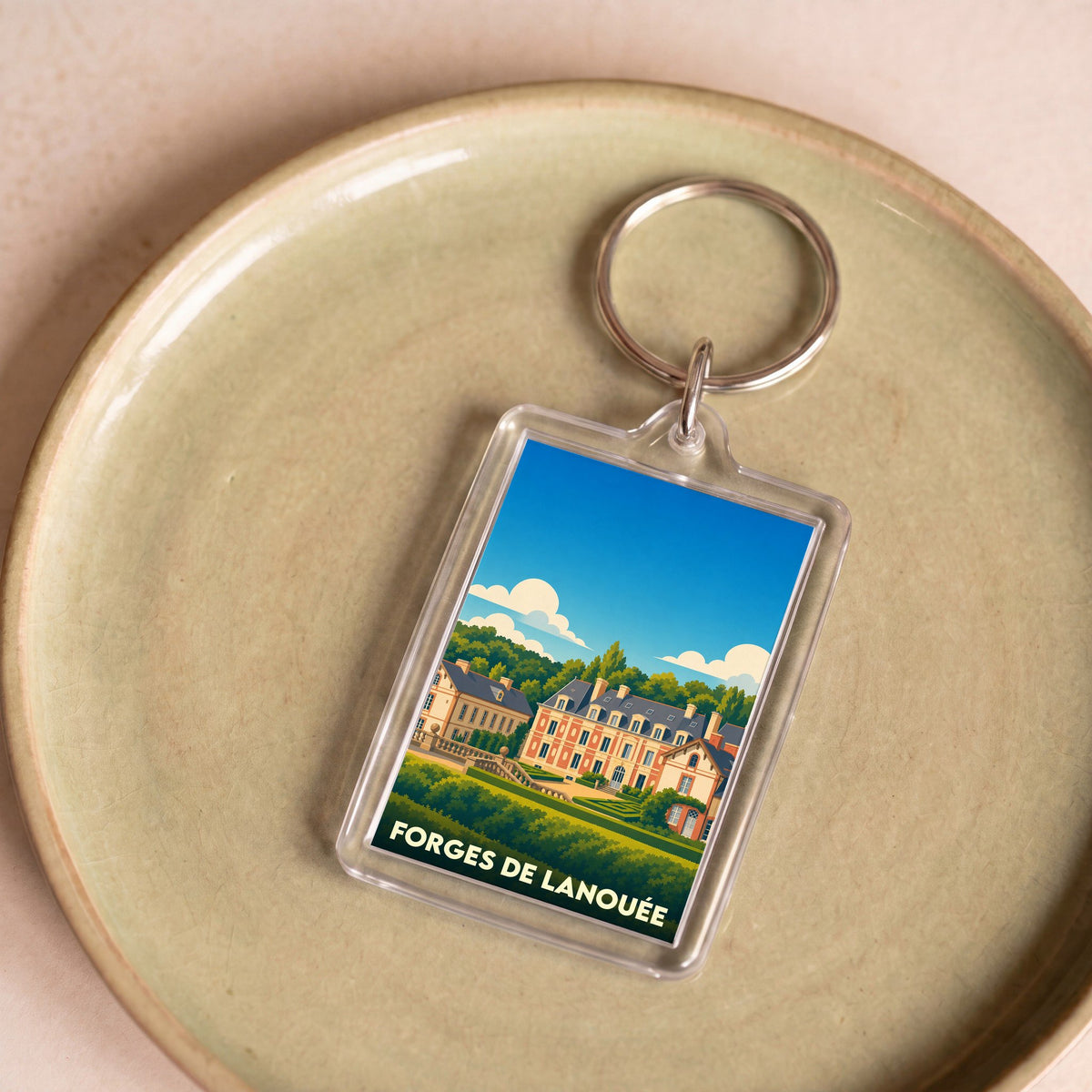 Porte-clés souvenir de la ville de Forges de Lanouée avec une illustration stylisée de son château.