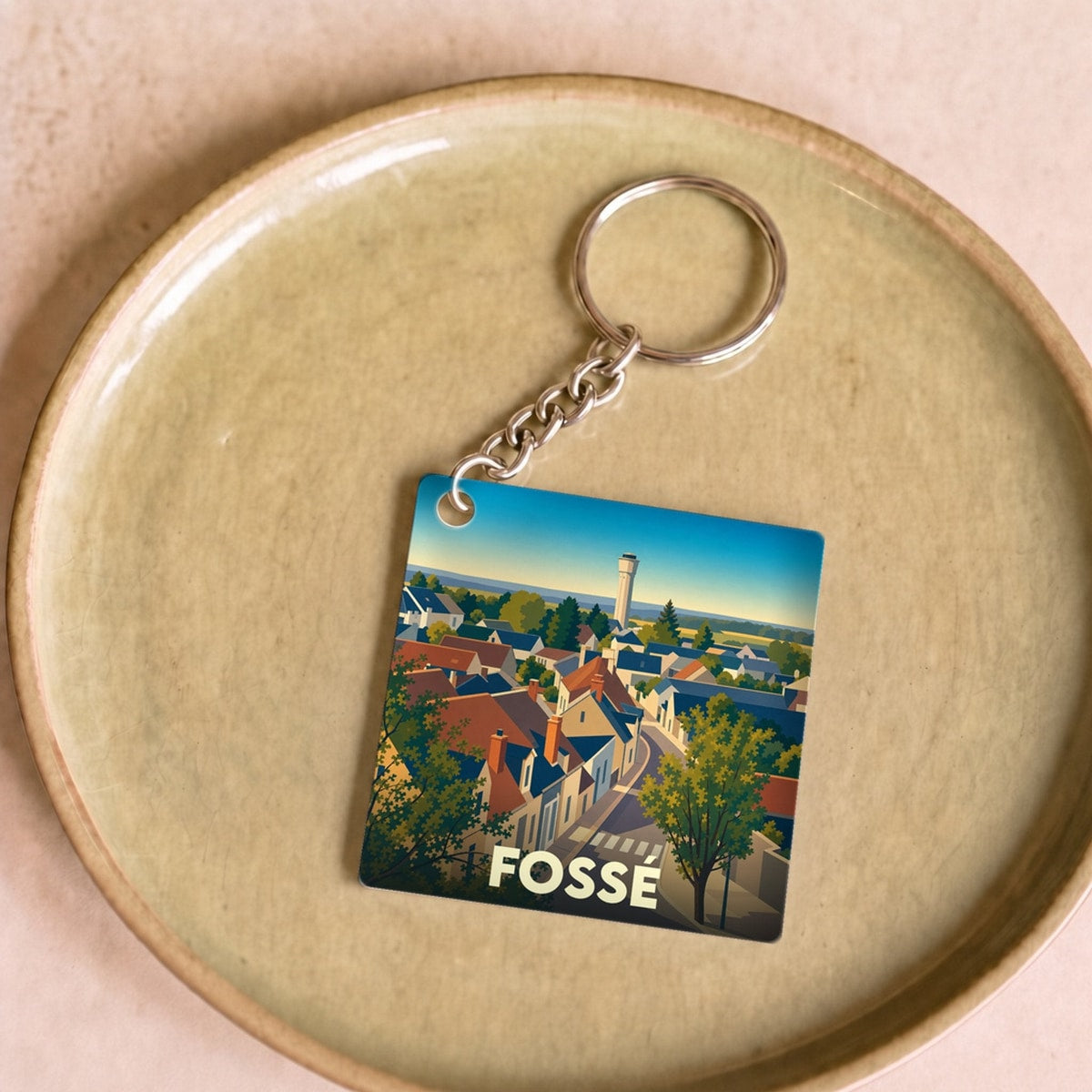 Porte-clés souvenir de la ville de Fossé avec une illustration stylisée de ses toits et de son château d'eau.