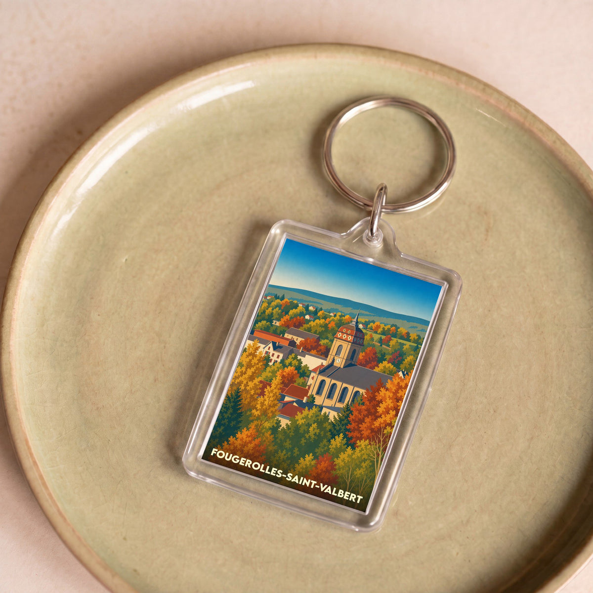 Porte-clés souvenir de la ville de Fougerolles-Saint-Valbert avec une illustration stylisée de son église en automne.