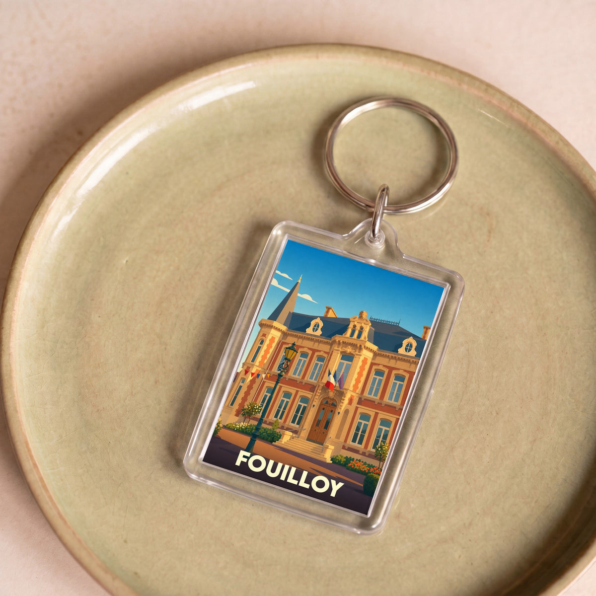 Porte-clés souvenir de la ville de Fouilloy avec une illustration stylisée de sa mairie.