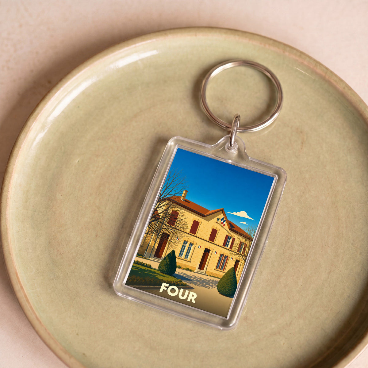 Porte-clés souvenir de la ville de Four avec une illustration stylisée d'un bâtiment officiel.