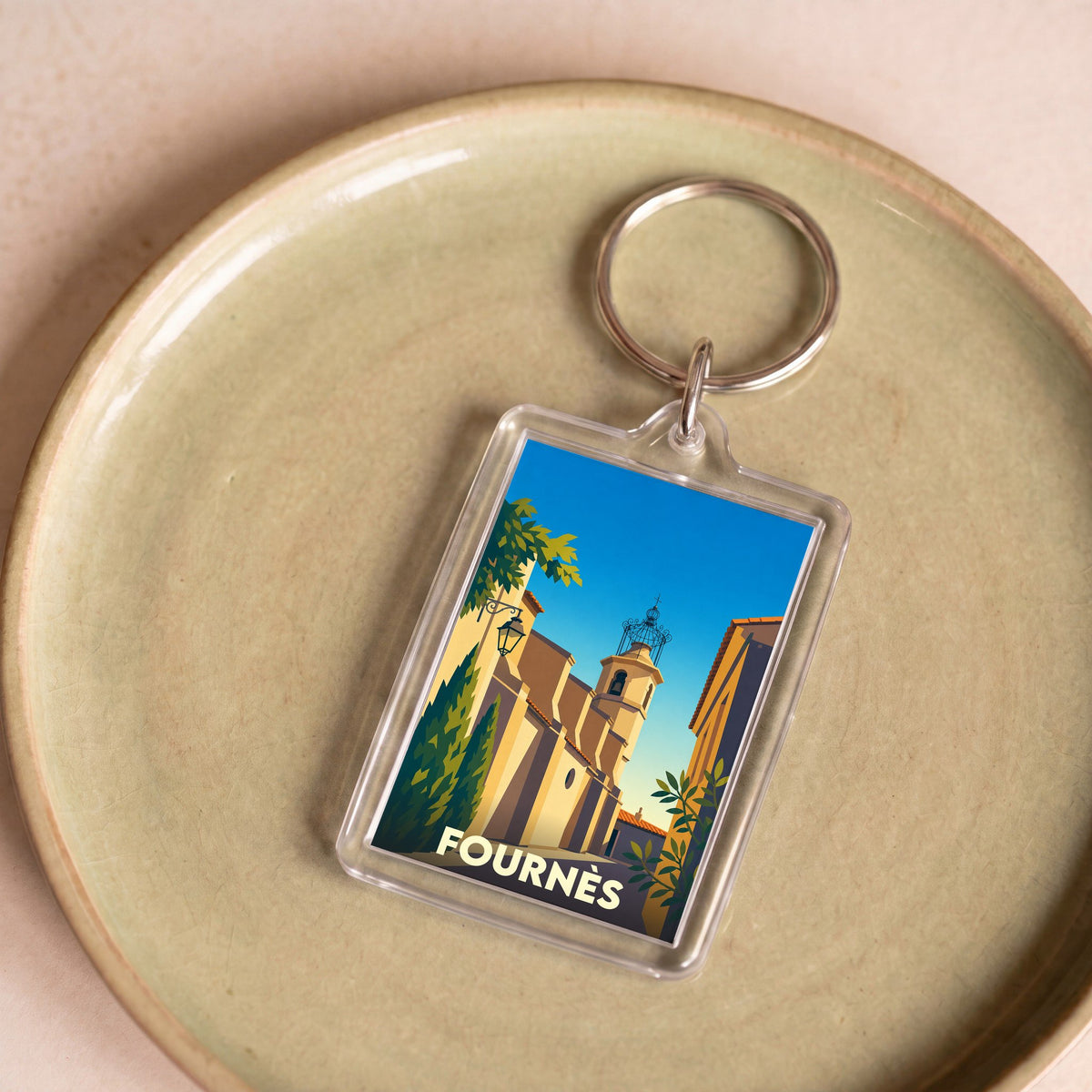 Porte-clés souvenir de la ville de Fournès avec une illustration stylisée.