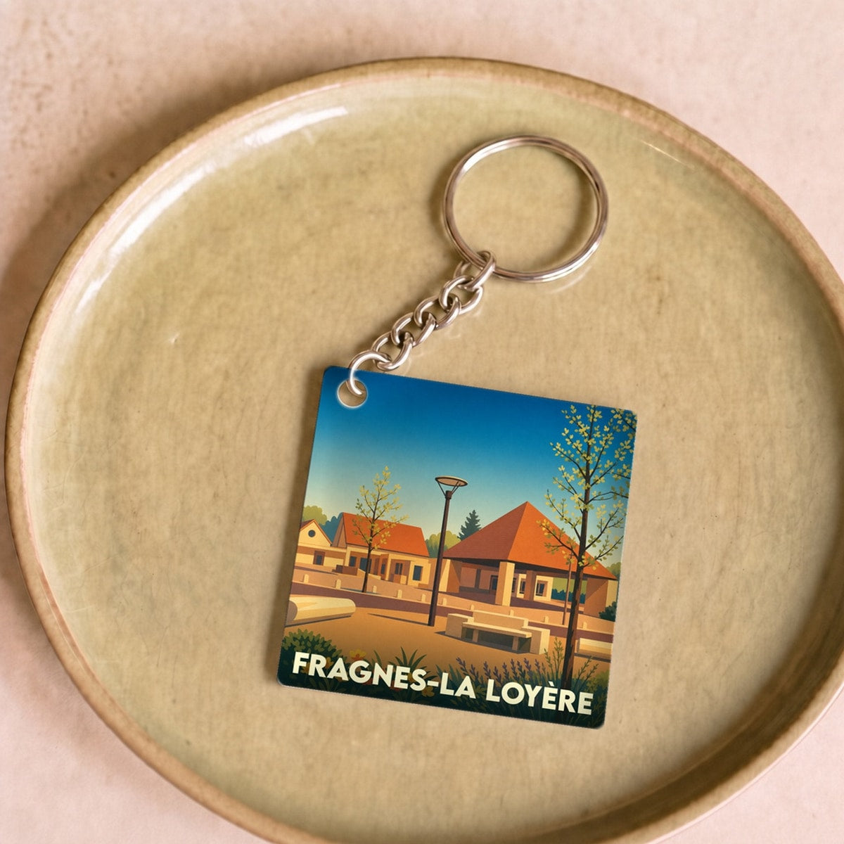 Porte-clés souvenir de la ville de Fragnes-La Loyère avec une illustration stylisée.