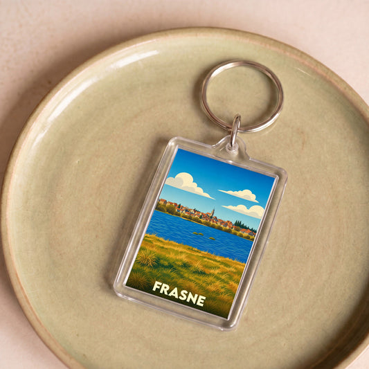 Porte-clés souvenir de la ville de Frasne avec une illustration stylisée.
