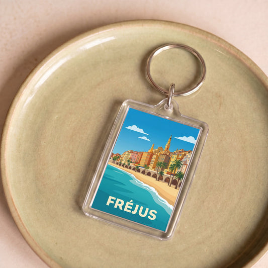 Porte-clés souvenir de la ville de Fréjus avec une illustration stylisée du front de mer.