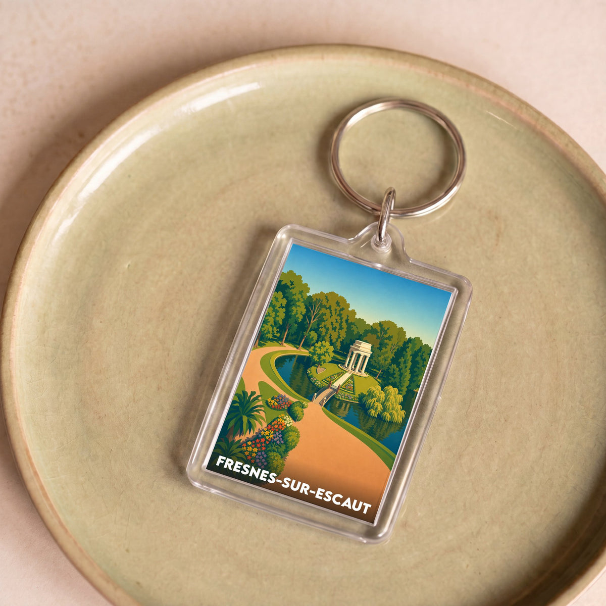 Porte-clés souvenir de la ville de Fresnes-sur-Escaut avec une illustration stylisée d'un parc.