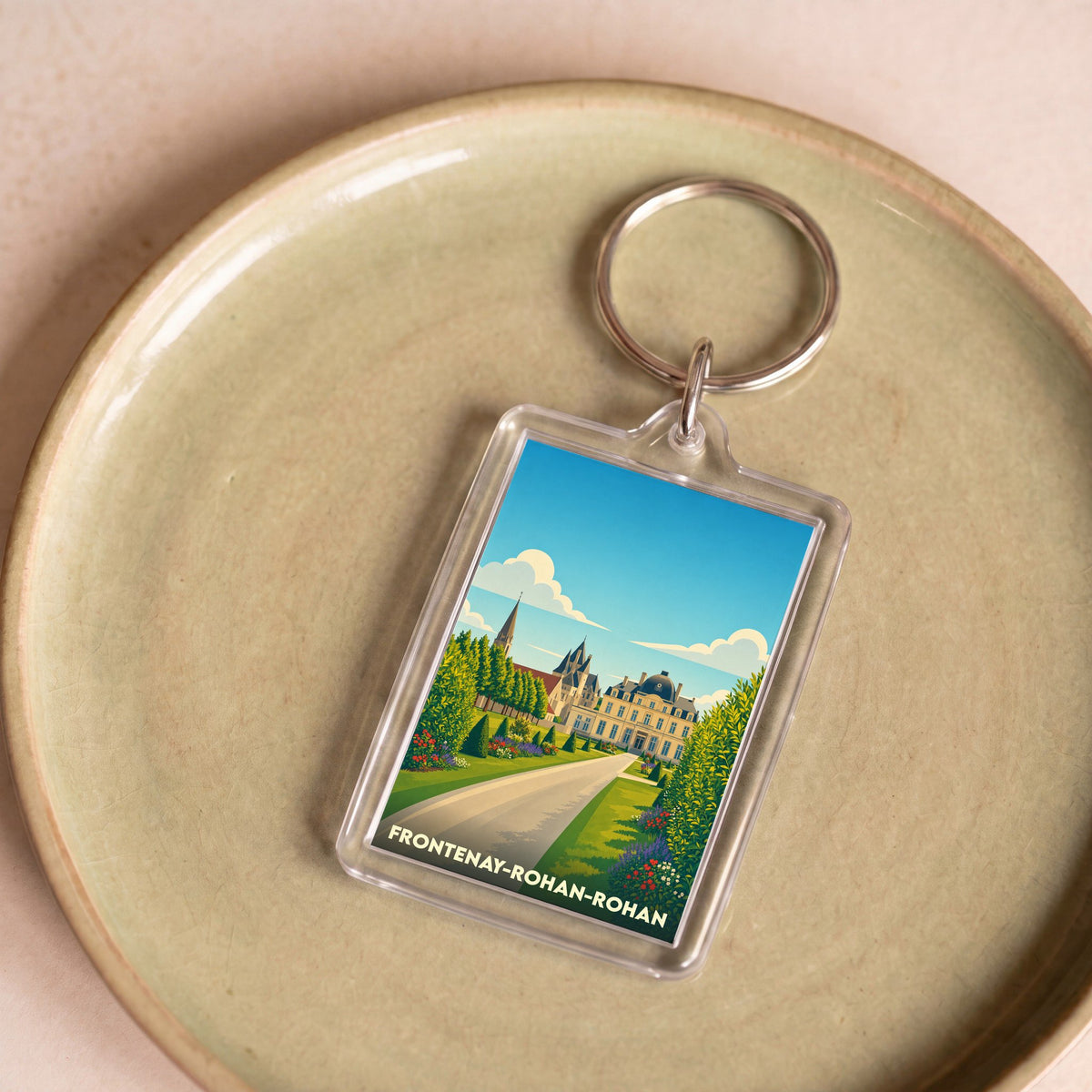Porte-clés souvenir de Frontenay-Rohan-Rohan avec une illustration stylisée de son château et de ses jardins.