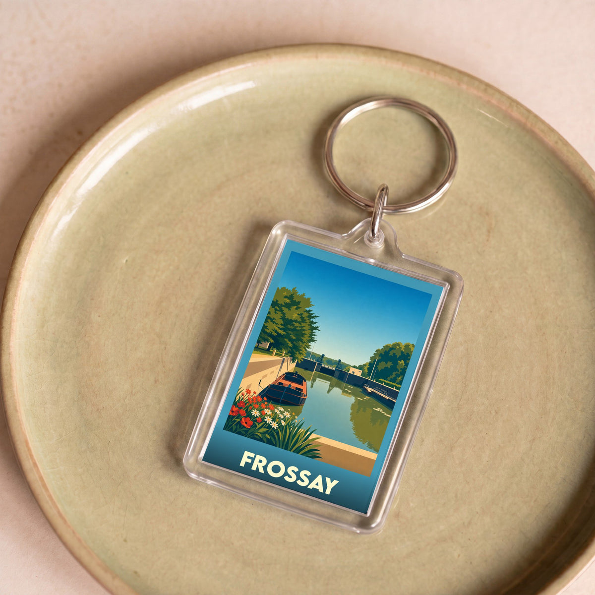 Porte-clés souvenir de la ville de Frossay avec une illustration stylisée d'un canal et de son écluse.