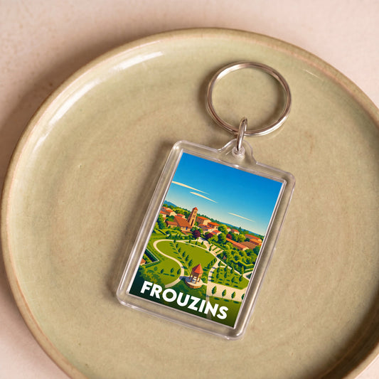 Porte-clés souvenir de la ville de Frouzins avec une illustration stylisée.